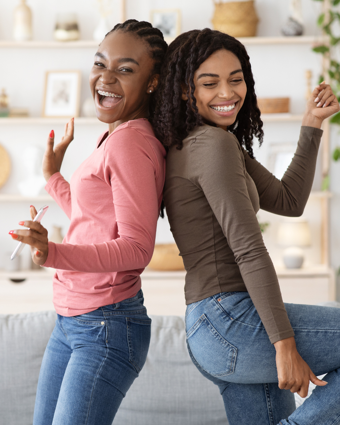 Deux femmes aux cheveux texturés souriantes lors d’un atelier capillaire à domicile